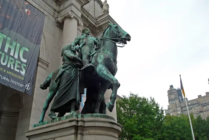 The statue of Theodore Roosevelt on a horse, with a Native American standing next to him (the African man standing next to him cannot be seen) outside the American Museum of Natural History